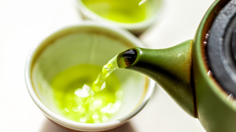 Green tea poured from green pot