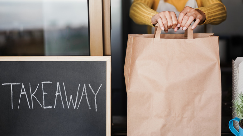 Person handing off takeout order 