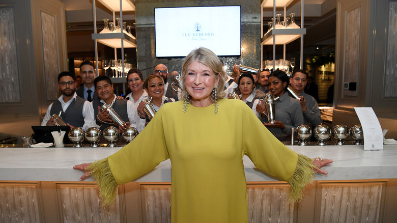 Martha Stewart in green dress posing for photo with The Bedford staff