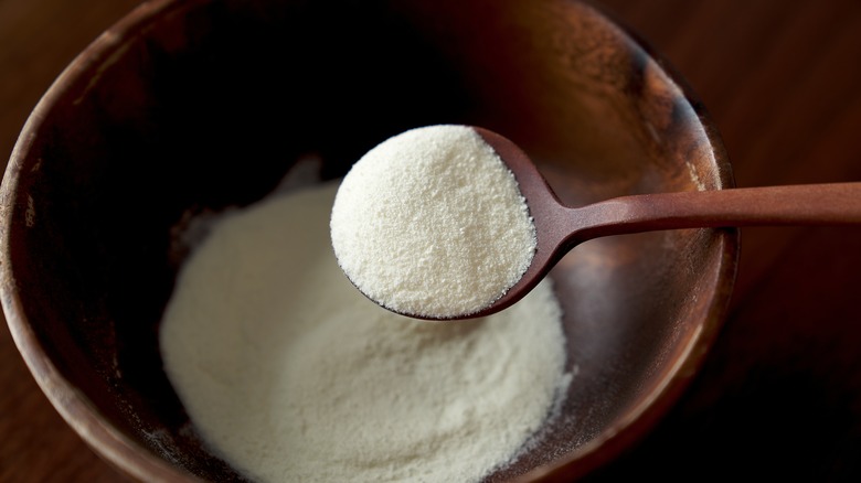 milk powder in wooden bowl and spoon