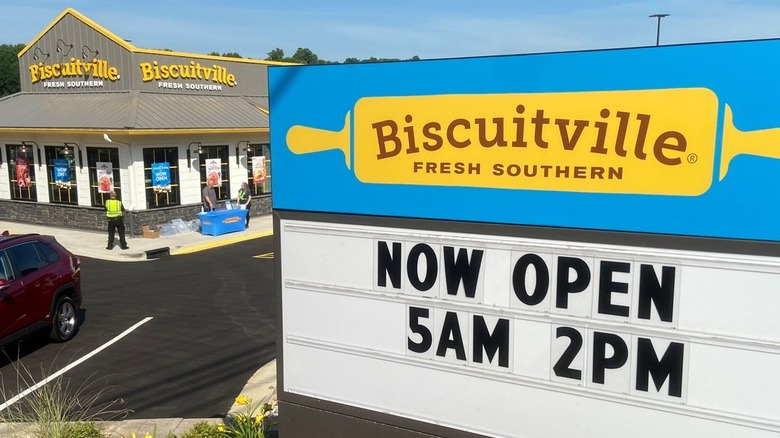 Sign in front of biscuitville store that says, "Now open from 5am to 2pm"