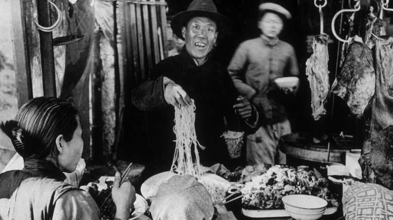 a man serving noodles