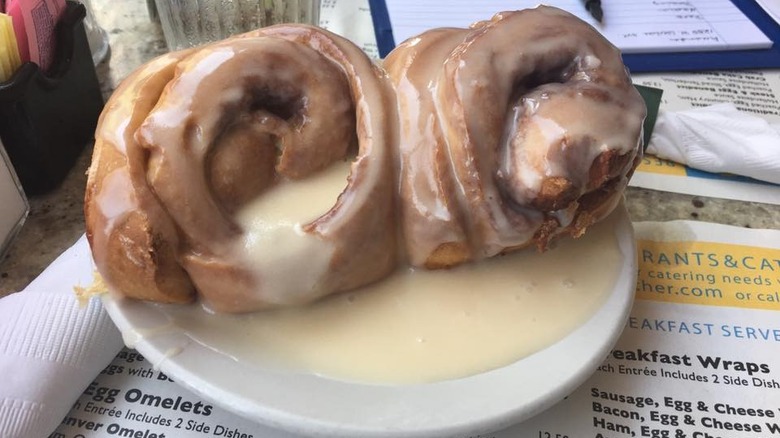 Pair of cinnamon rolls with glazed icing on plate
