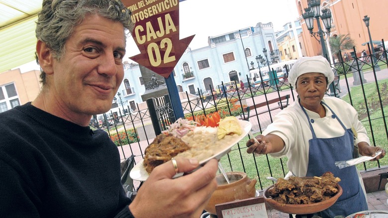 Anthony Bourdain holding a plate of food