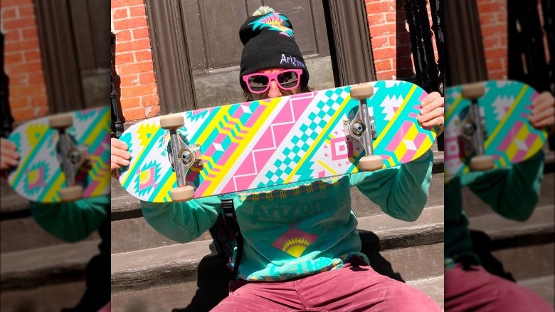 man holding arizona iced tea skateboard