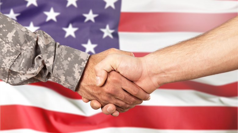 shaking hands in front of flag