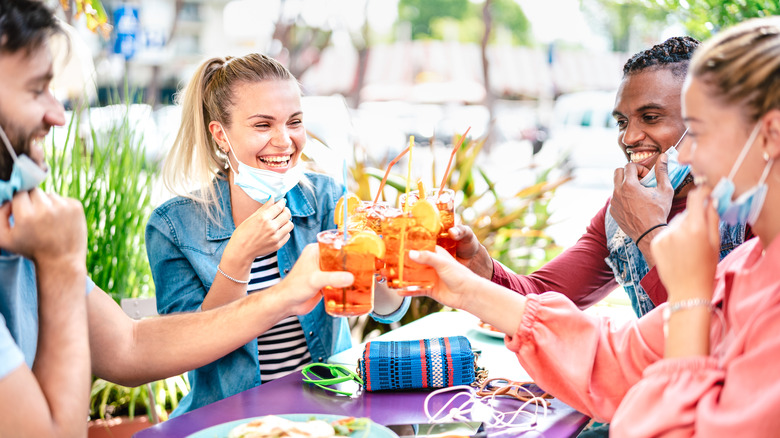 group of people wearing face masks at happy hour