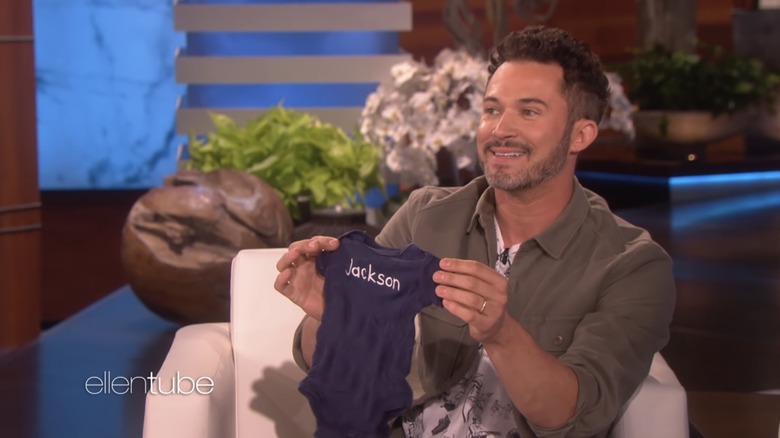 Justin Willman holding "Jackson" onesie