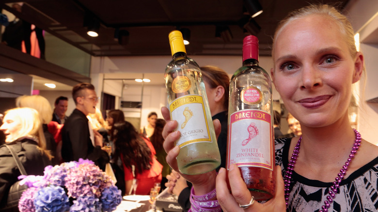 woman holding barefoot wine bottles