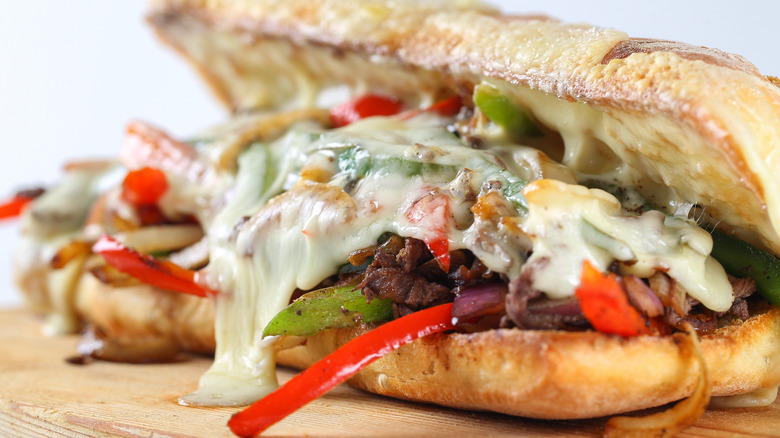 A Philly cheesesteak sandwich on a wooden board