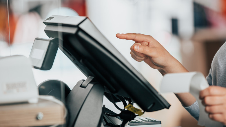 A person punching things into a register system