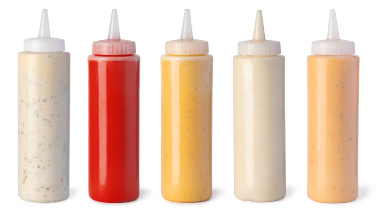 Five bottles of sauces lined up