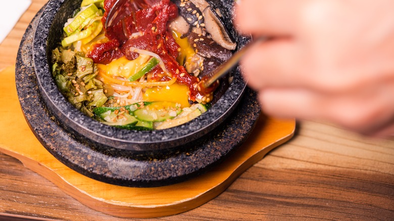 Closeup of bibimbap being mixed before eating