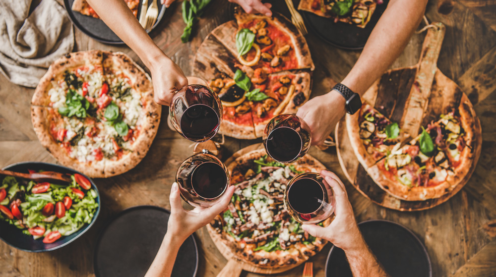 Friends at a pizza party with red wine