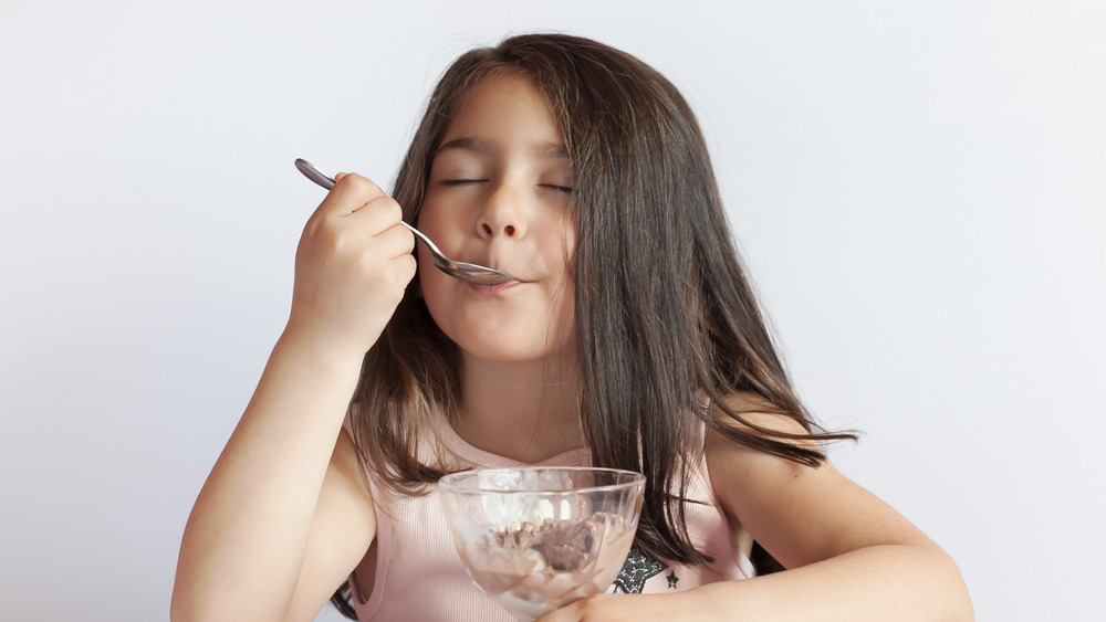 Child eating ice cream in bowl 