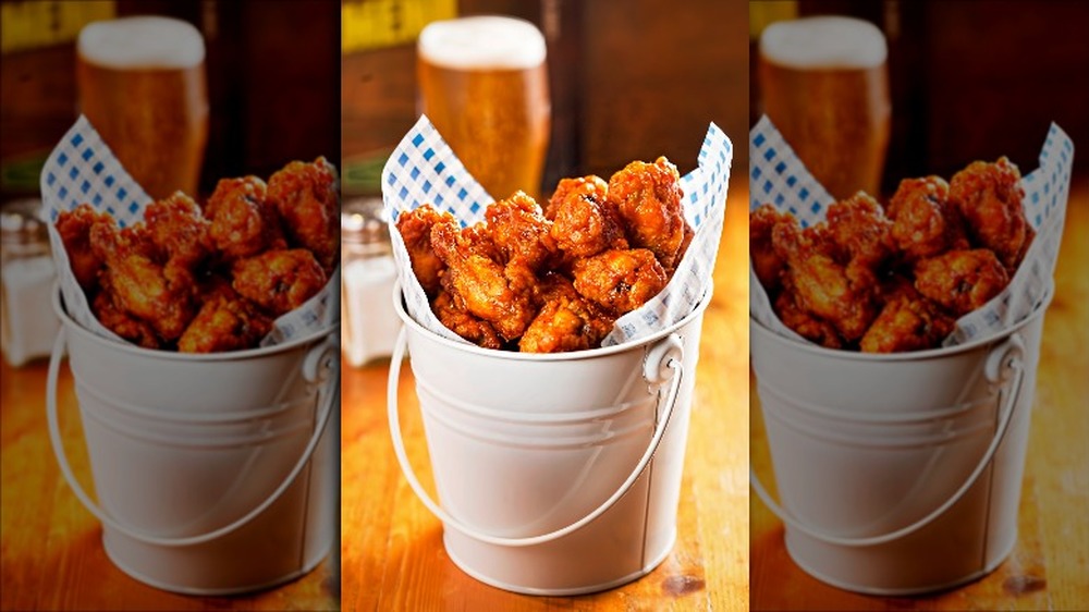 Bucket of Buffalo wings with beer