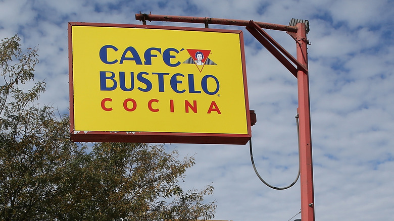 밝은 노란색 사인을 읽는 카페 Bustelo Cocina