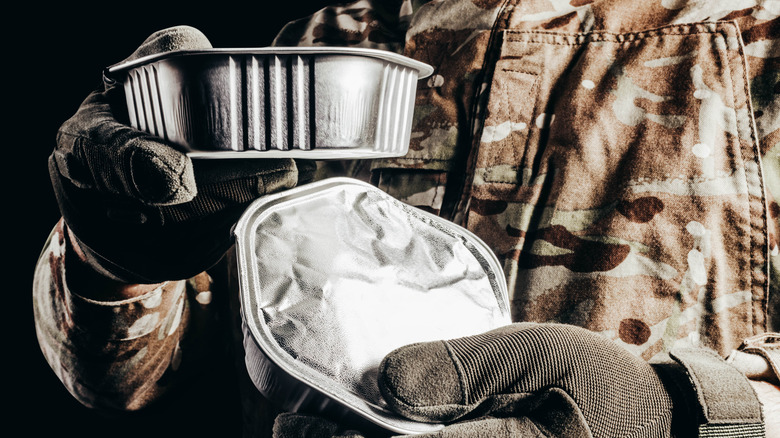 Soldier holding rations of sealed meals