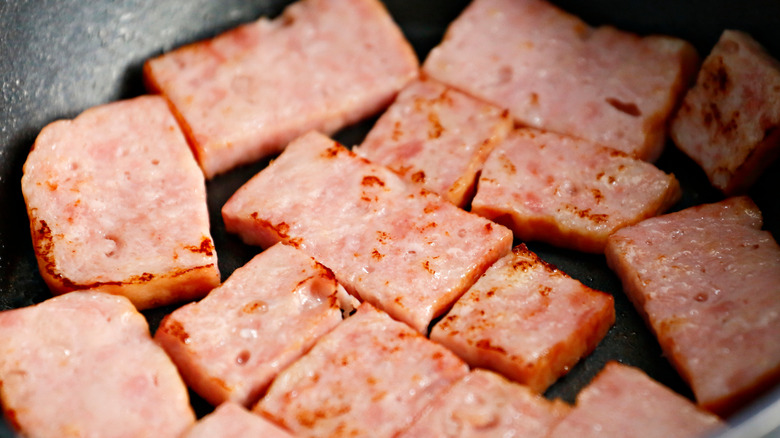 sliced canned ham cooking in a skillet