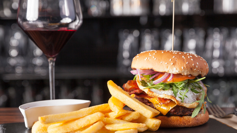 Glass of red wine with burger and fries