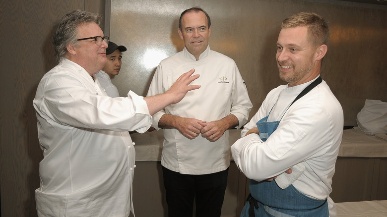 Chefs Charlie Palmer, Bryan Voltaggio, and David Burke smiling and talking with each other