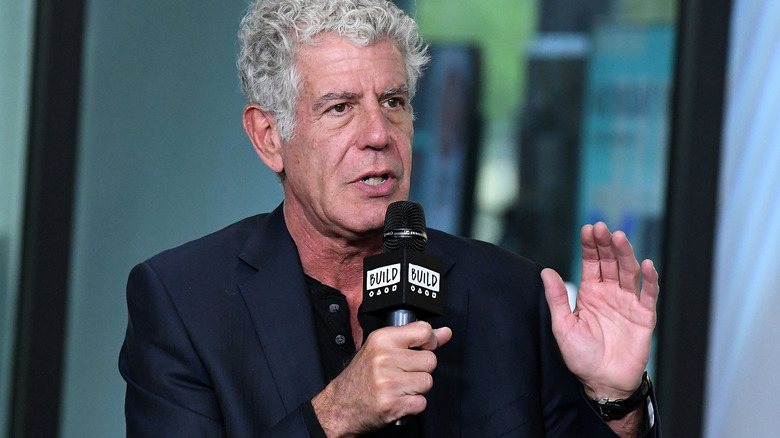 Anthony Bourdain speaking into a microphone