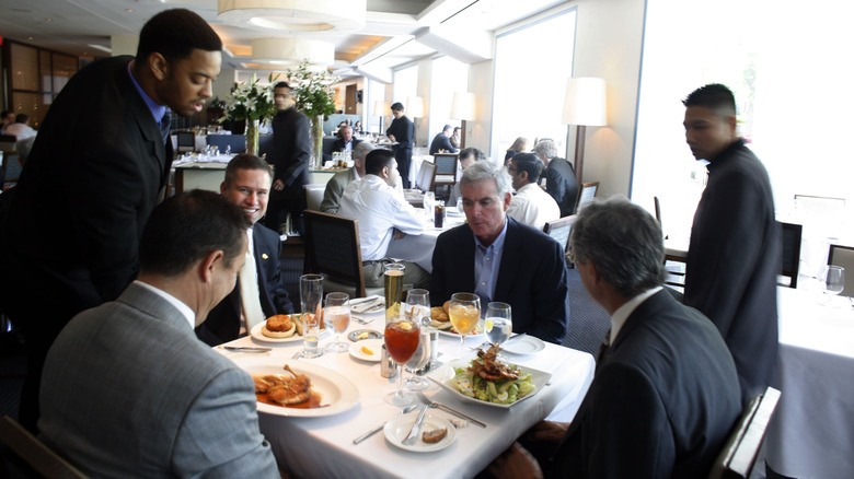 Men in suits eating food at Charlie Palmer Steak