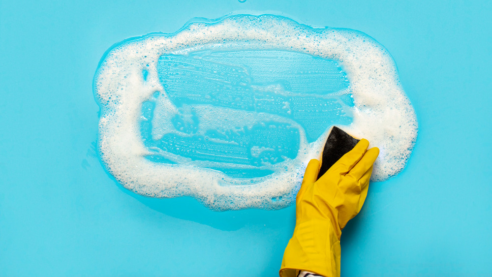 A hand scrubbing the floor