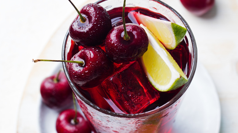 Cherry Coke topped with cherries and limes