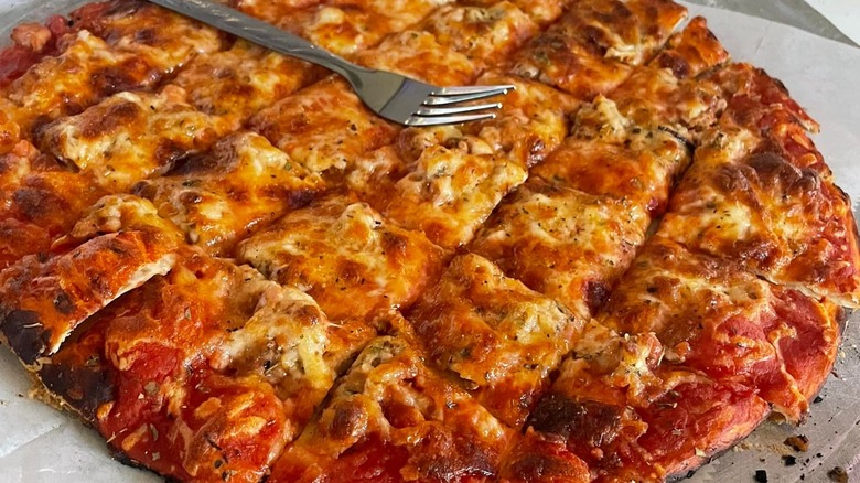 tavern-style pizza cut into squares with fork on top