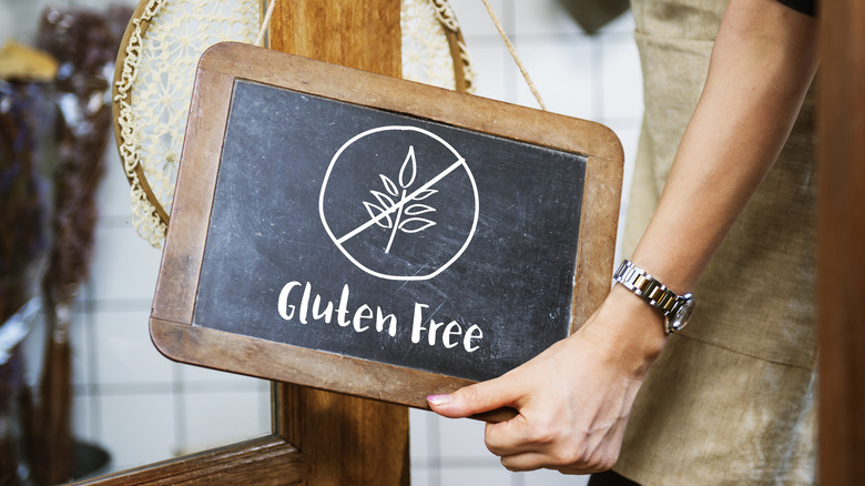 Person holding a gluten free chalkboard sign