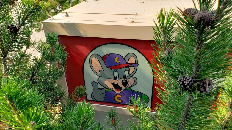 Chuck E. Cheese outside block behind trees