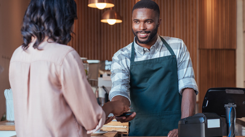 Woman pays for coffee at cafe