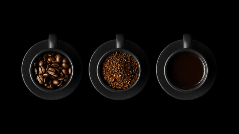 Coffee beans, grounds, and brewed coffee in black cups