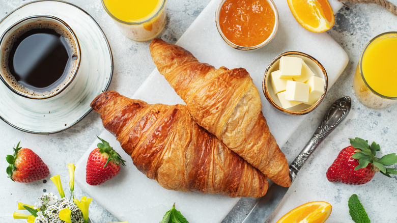 croissants, fruit, and coffee top view