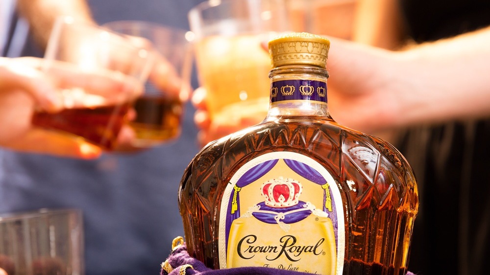 Crown Royal bottle with people toasting in background 