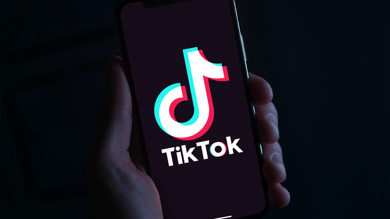 Person holding phone with TikTok screen