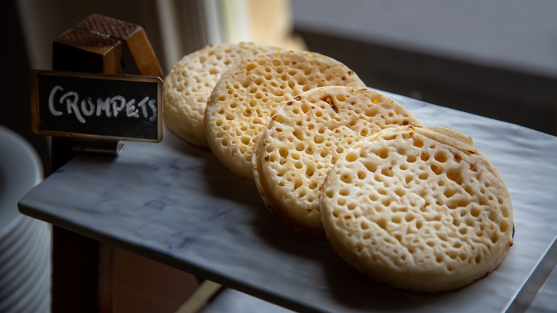 four crumpets on a stone slab