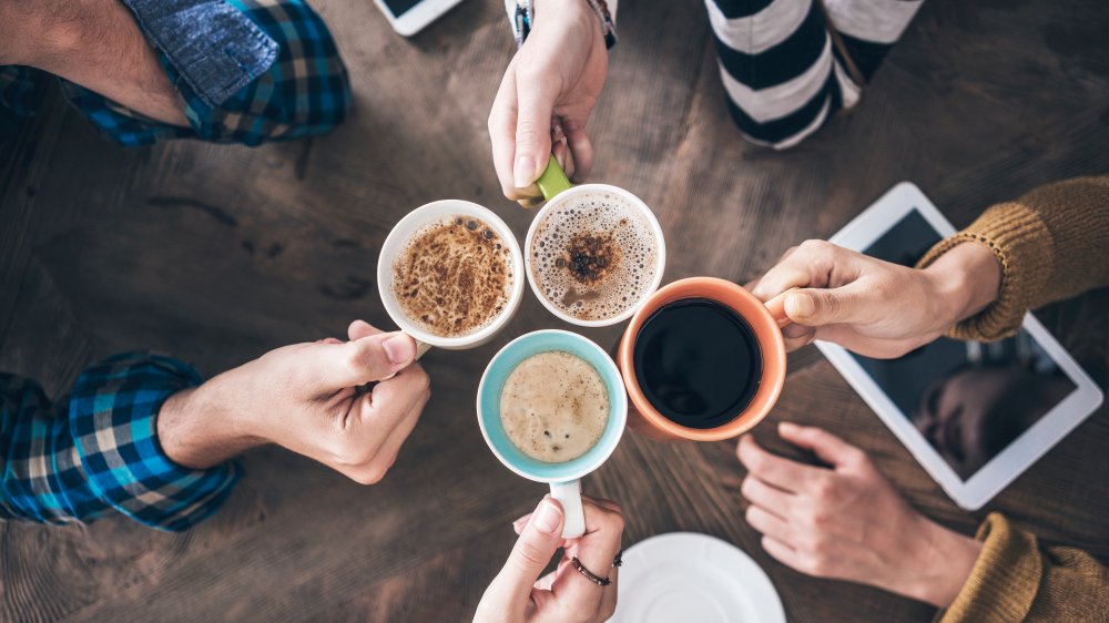 people holding cups of coffee