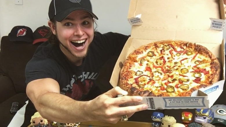 A man holding a pizza