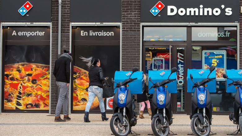 Blue scooters near Domino's storefront