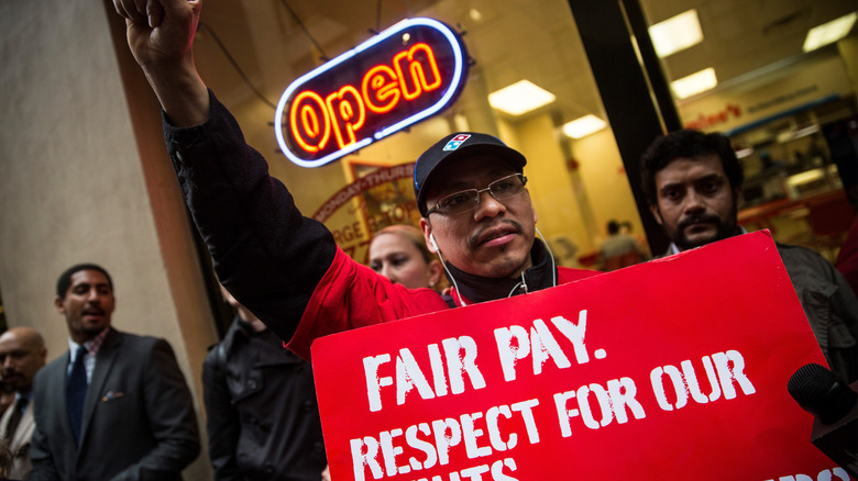 Domino's employee holding a sign