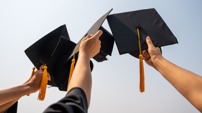 Graduation hats raised to sky