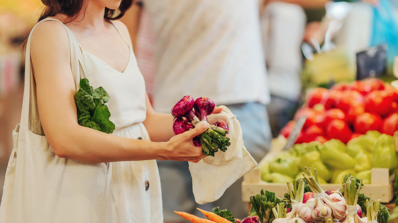 A person picking up purple produce