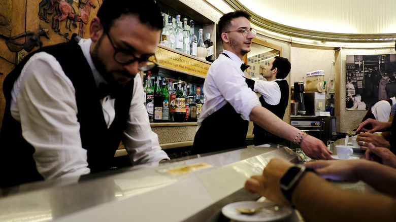 serving espressos at bar counter