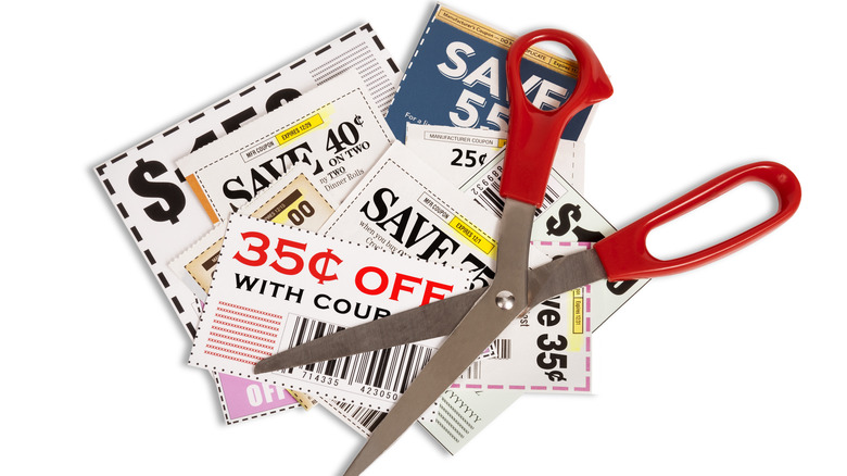 Red scissors on stacked coupons