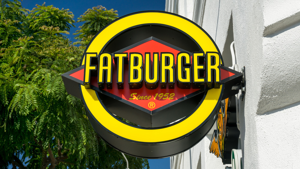 A Fatburger sign in front of trees