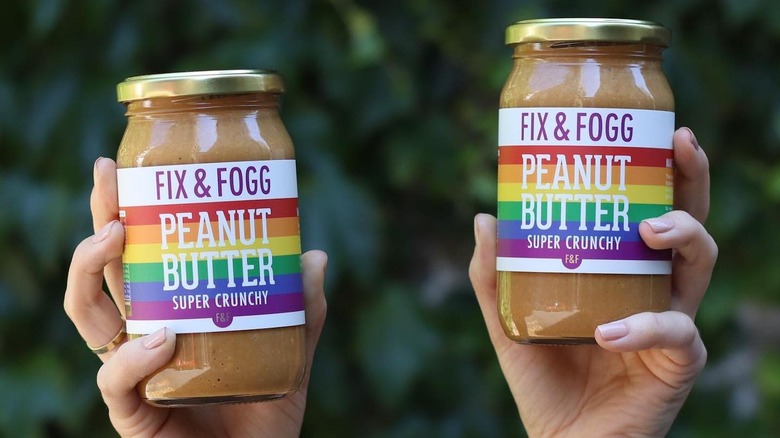 hands holding Pride Fix & Fogg peanut butter