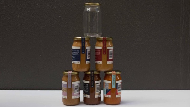 Tower of Fix & Fogg peanut butter jars with one empty jar