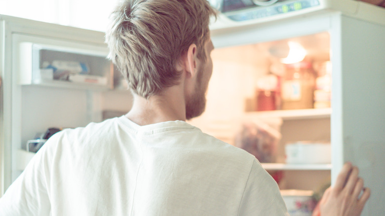 man opening freezer door